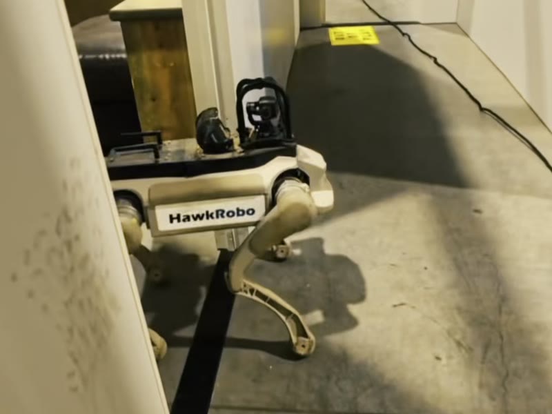 The robot stepping through a doorway in a training building