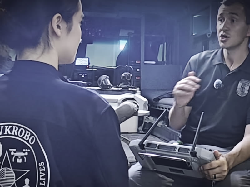 A HawkRobo team member talking with an agency representative who is holding the controller